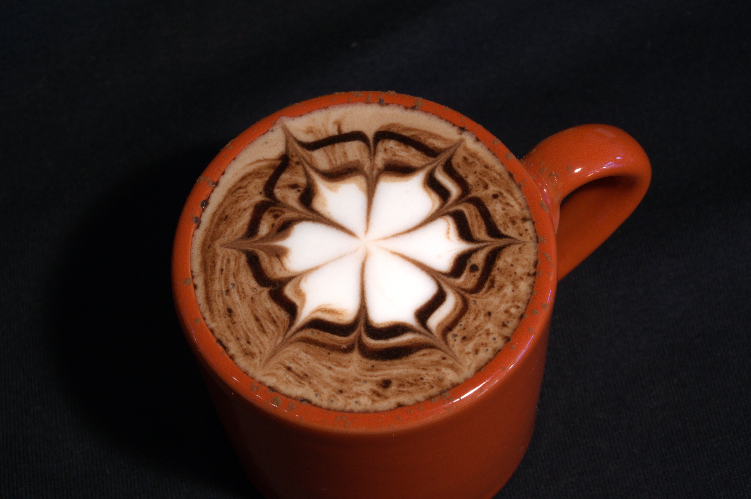 Mocha latte art in orange cup